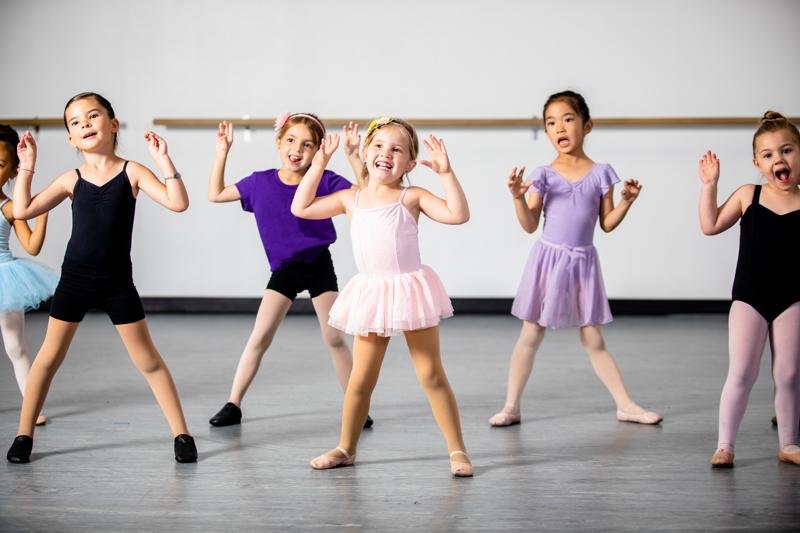 A diverse young group of students practice in musical theatre and ballet combo dance class