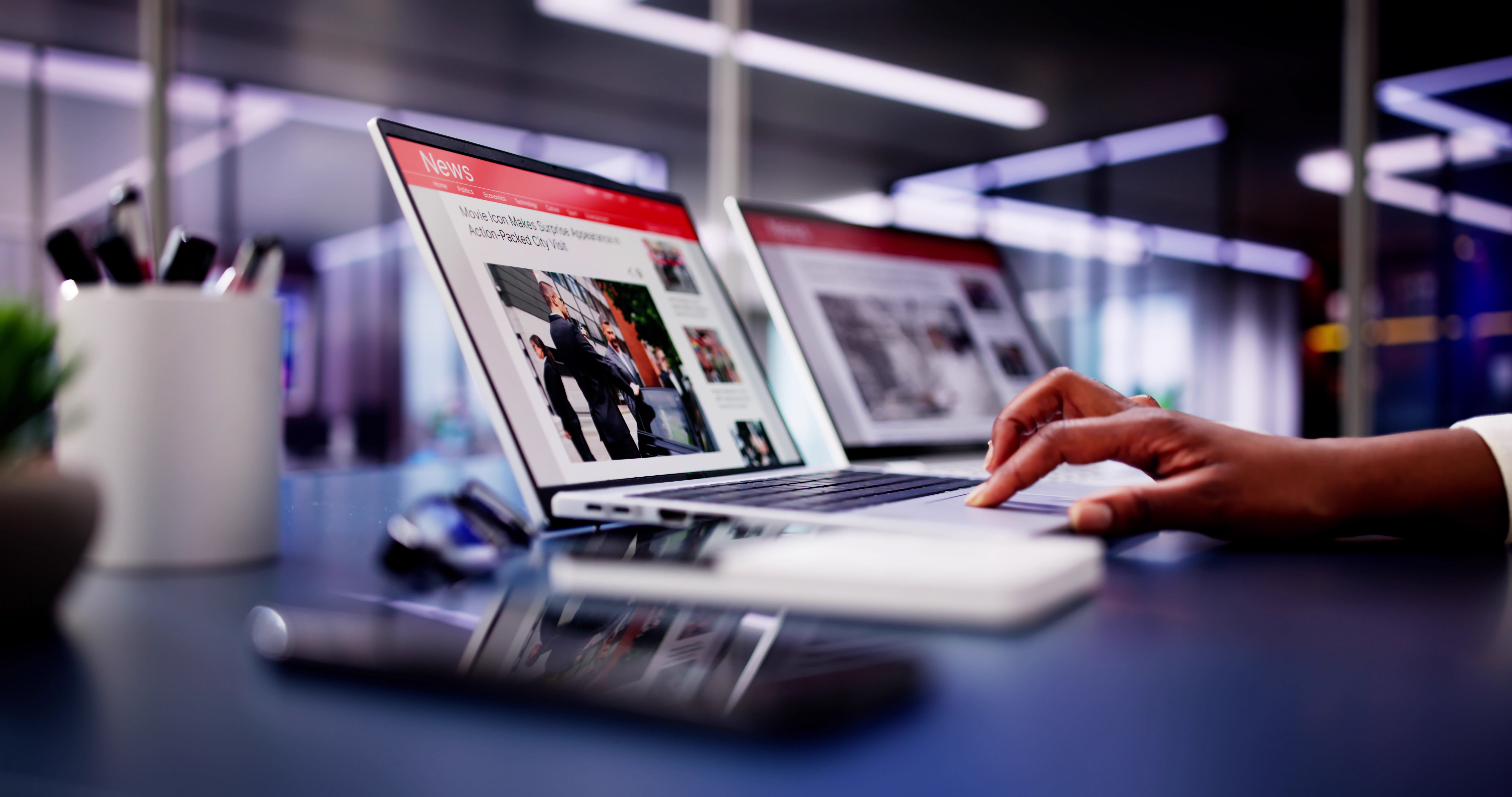 American Woman Views Online News Articles on Laptop and Phone While Relaxing on Sofa in Black and White Room