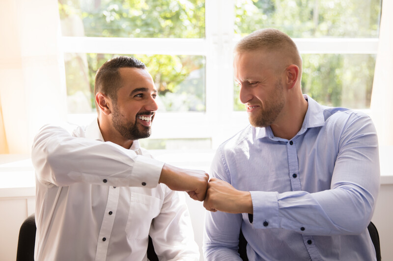 Close-up Of Two Happy Male Making Fist Bump