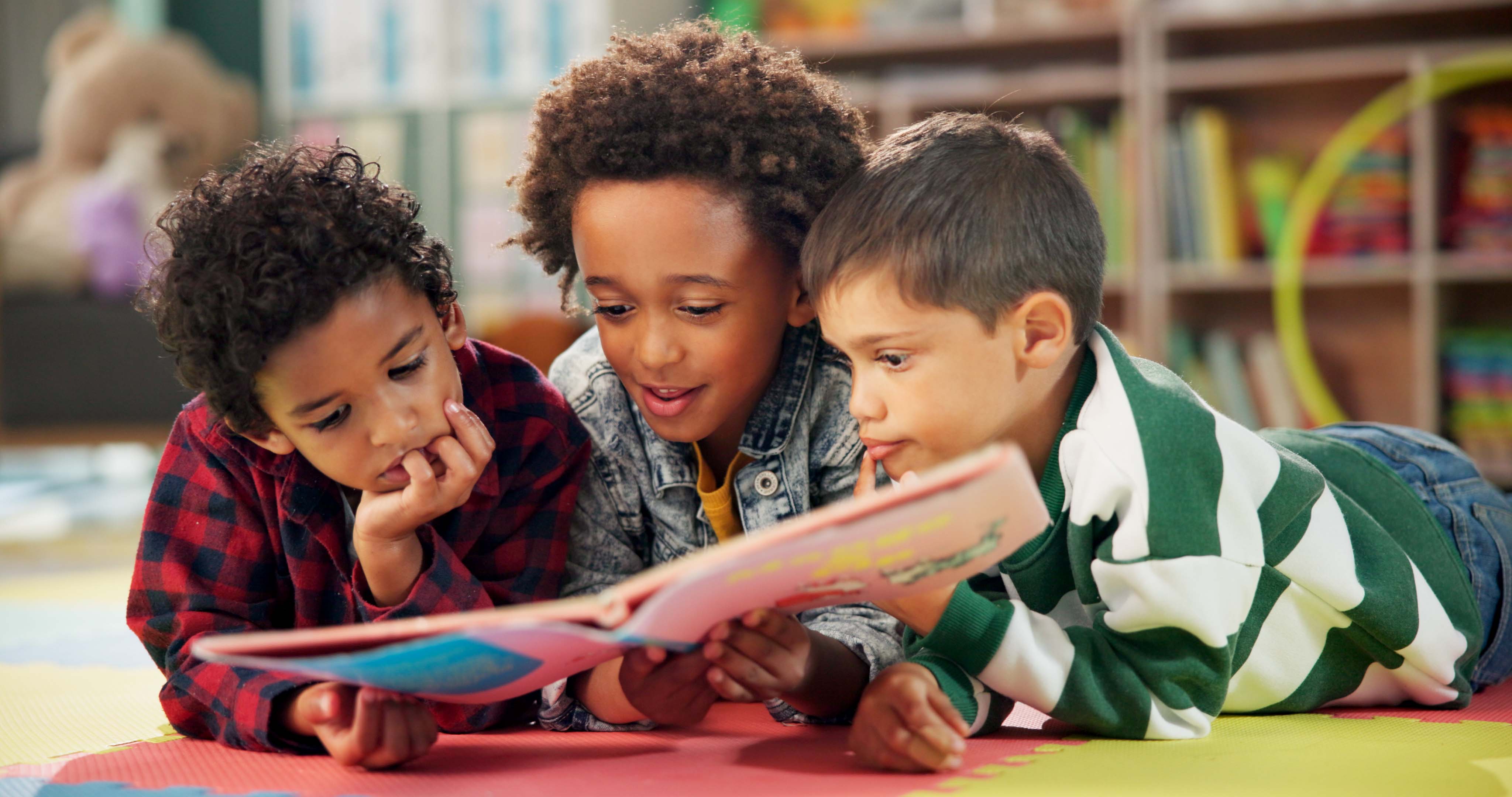 Children, book and reading on floor at school, learning and literacy knowledge or mind development. Boys, kids and storytelling for education, english and literature information on mat for language