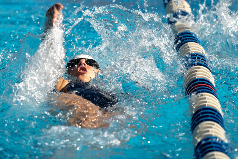 girls swimming backstroke at a summer swim meet