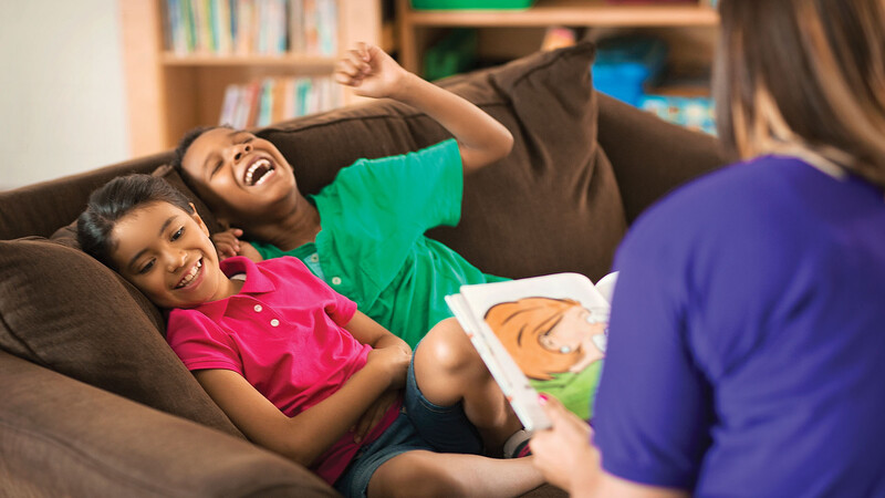 Children reacting to a story narrated by a woman 